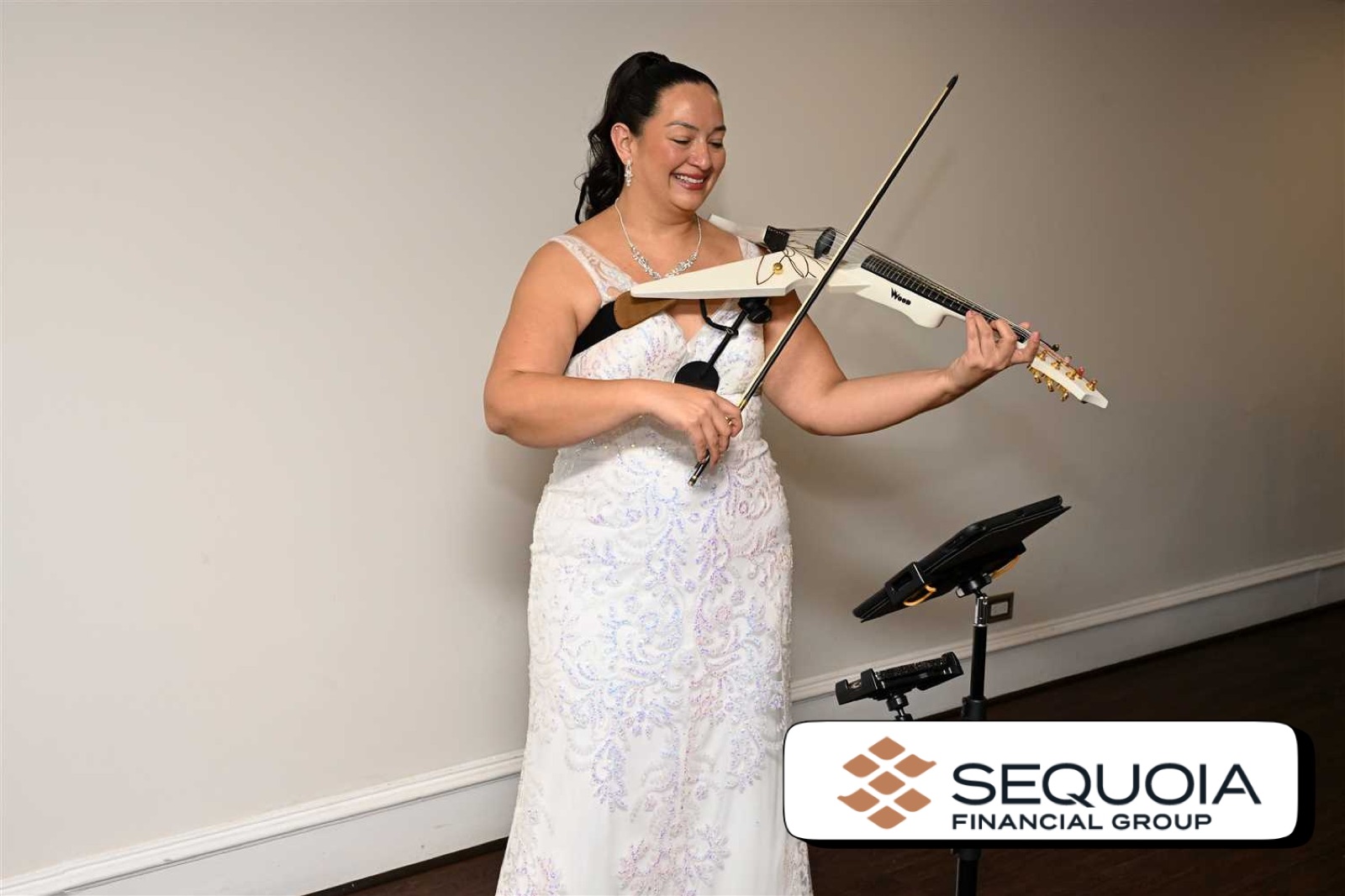 Founder of Luxe Harmony in a white gown playing her violin, offering information about wedding violinist prices.